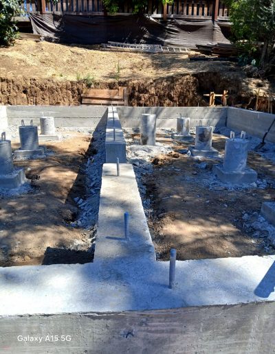 Completed deep concrete piers and perimeter grade beams for a new foundation built on a sloping or challenging site.